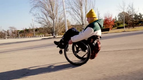 Young Man Enjoying Freedom and Mobility in Wheelchair at Park