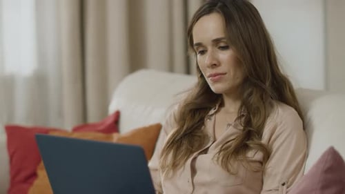 Woman Working on Laptop on Sofa
