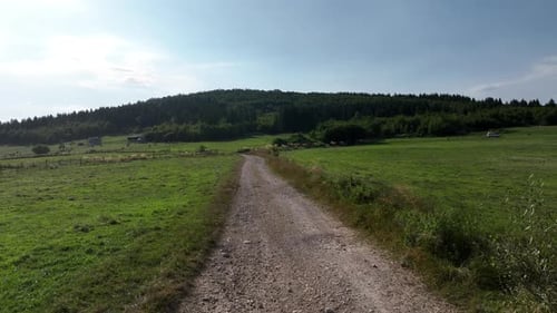 Aerial Shot of a Motocross Rider on a Journey on a Dirt and Dusty Country Road Driving Fast and