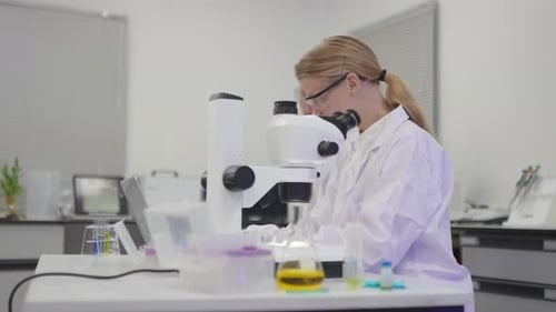 Scientists Analyzing Samples with Microscope in Laboratory Setting