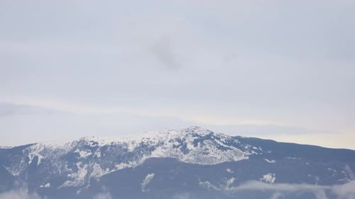 Zeitraffer bewegter Wolken in schneebedeckten Bergen. Kreativ Wolken im verschneiten felsigen Berg bedecken