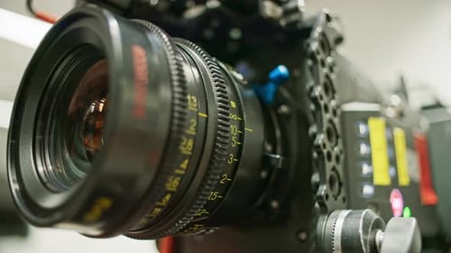 Focus ring of a professional cinema camera turning, focus distance changing. Lens elements and iris