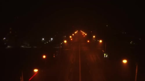 Spooky road and street lights at night with an empty road. Romania, Cluj-Napoca. Foggy night, Aerial