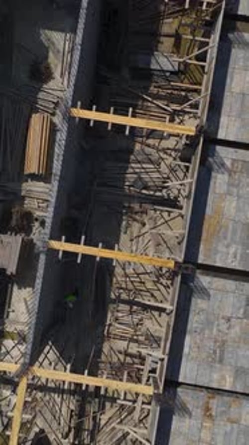 Vídeo vertical: los trabajadores construyen paredes para un nuevo piso mientras los ingenieros supervisan el progreso de la construcción