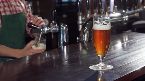 Refreshing Craft Beer Glass Glistening on the Bar Bartender Skillfully Pouring in the Background