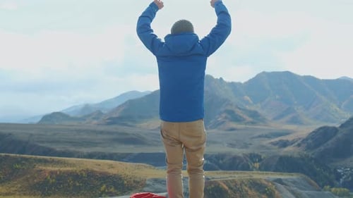 The Happiness Scene Man Alone Raised Hands Standing on the Edge of the Stones Against High Rocky
