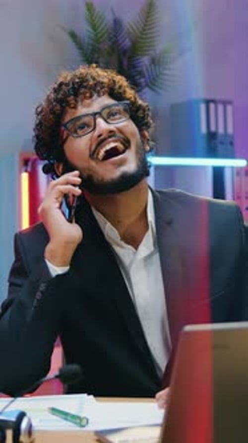 Cheerful Man Talking on Phone in Colorful Office