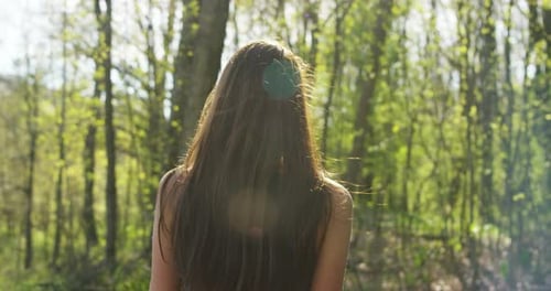 slow motion of a young beautiful girl with athletic body breathe deeply in a forest to enjoy the b