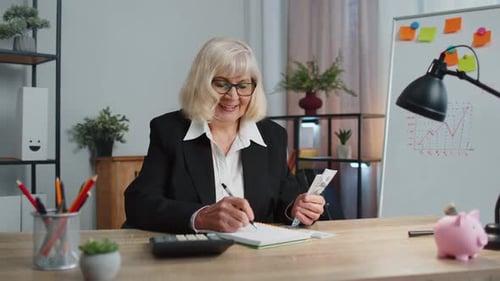 Senior Business Office Woman Accountant or Banker Using Calculator Making Money Cash Calculations