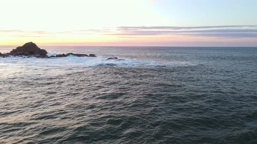 Raging Sea in the Morning at Dawn Waves Roll on the Rocky Shore Spray Soars Into the Sky