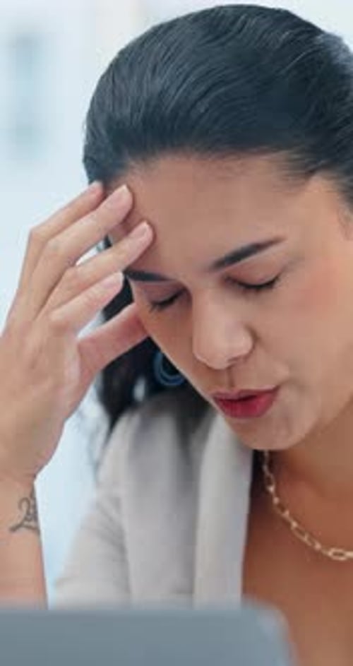 Woman, headache and pain with stress on laptop for mental health, pressure or vertigo at office
