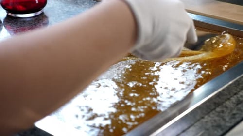 Closeup of a Pastry Chef Mixing Liquid Sugar Caramel with a Spatula