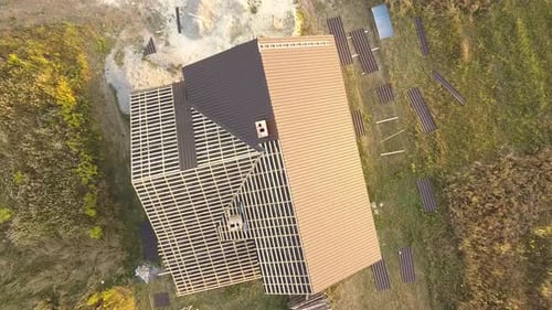 Aerial View of Unfinished House with Wooden Roof Structure Covered with Metal Tile Sheets Under