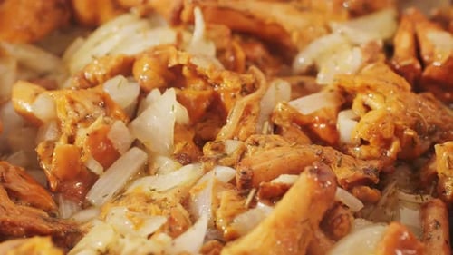 Cuisiner des chanterelles, gros plan, macro, champignons grillés, gros plan, chanterelles rôties et une cuillère en bois