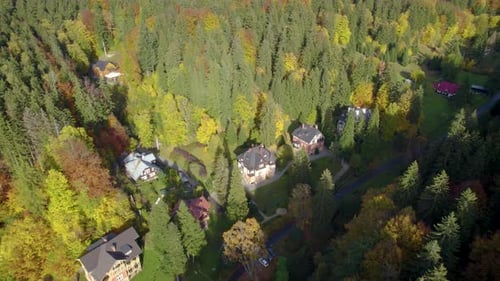 Luftumlaufbahn über dem schönen Dorf versteckt im Bergwald im Herbst
