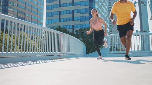 Athletes Run on Bridge in Urban City