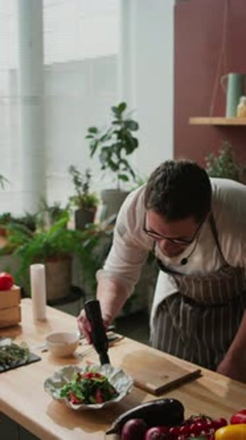 Chef Adds Sauce to a Salad in Kitchen
