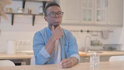 Young Adult Thinking at Table Indoors