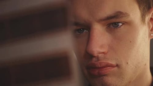 Face Of A Man Looking At Film Negatives In Blurred Foreground. closeup