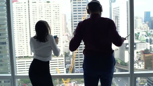 Businesspeople Listening to Music and Dancing by Window in Office, Super Slow