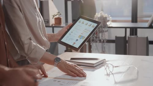 Coworkers Analyzing Data on Tablet and Documents