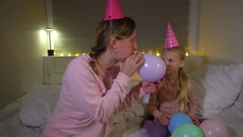 Mother Blowing up Balloons for Birthday Party