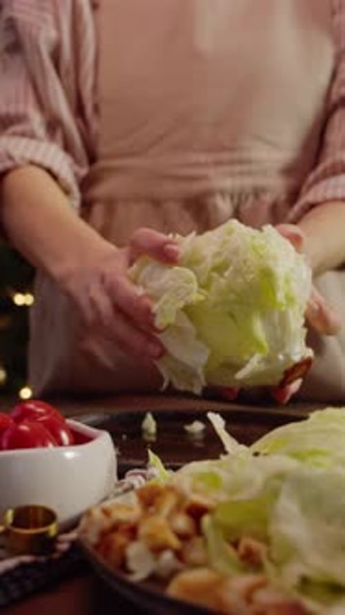 Young Woman Prepares Delicious Salad Based on Iceberg Lettuce or White Cabbage Leaves Which She