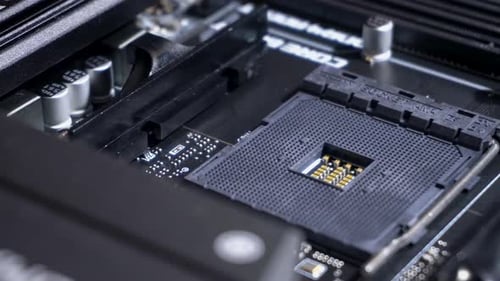 Central processing unit (CPU) pin grid array socket inside computer, slow pan right, close up