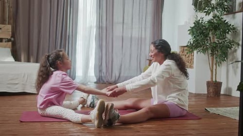 Woman and Child Stretching Together at Home