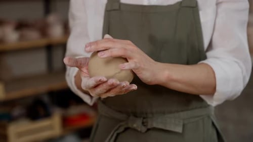 Woman Shaping Clay with Hands in Pottery Studio