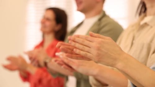 Group of people clapping hands indoors, selective focus