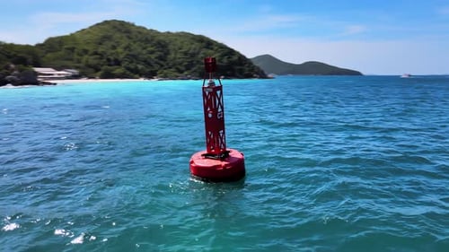 4K-Drohnenaufnahmen aus der Luft, die eine rote Boje umkreisen, die in den Wellen in der Nähe der Küste des exotischen R