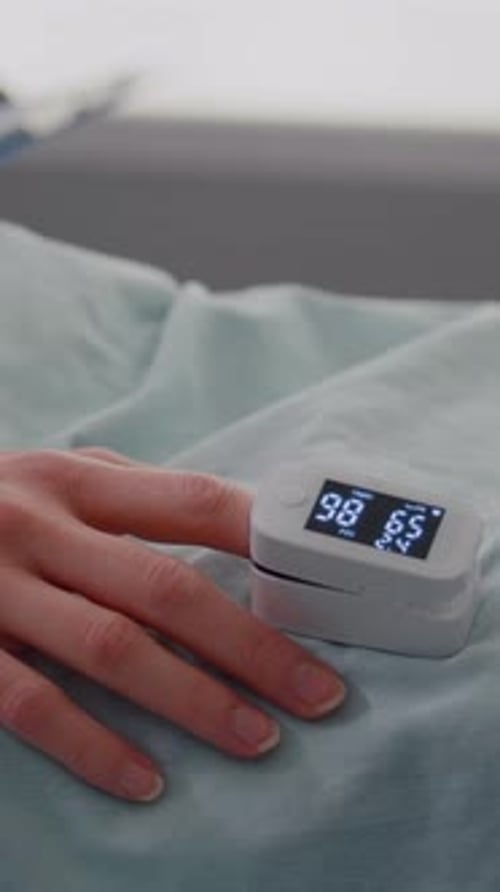 Primer plano Vídeo de una mujer hospitalizada con un monitor de frecuencia cardíaca con un dedo que muestra el pulso
