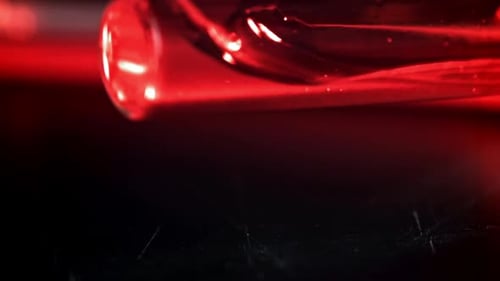 Ein Reagenzglas mit Blut fällt auf den medizinischen Tisch, gefilmt mit einer Hochgeschwindigkeitskamera mit 1000 Bildern pro Sekunde
