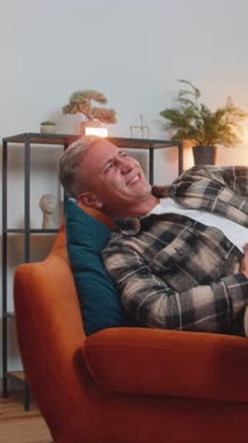 Man Experiencing Stomach Pain on a Couch