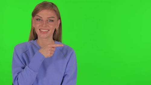 Woman Pointing on Copyspace on Green Background