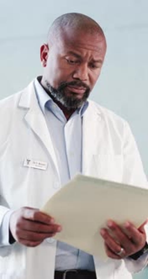 Black man, doctor and intern with folder at hospital for medical file, patient history