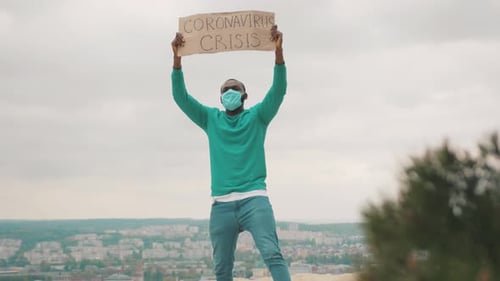 Un réalisateur afro-américain licencié tient une bannière de crise avec des slogans de grève pour l'emploi