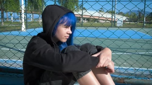 Worried Teenager By Fence