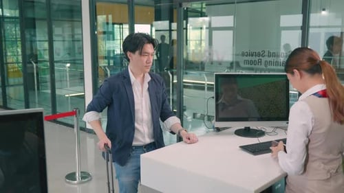 Male tourist in international airport at check-in counter checking staff giving passport