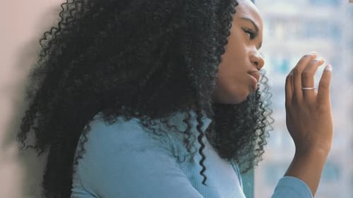 sadness, solitude - sad african woman looks out the window thinking