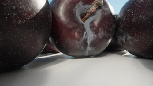 Large plum under the sun and blue sky. Dolly slider extreme close-up. Laowa Probe