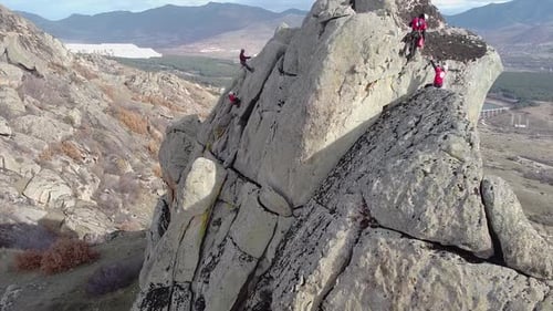 Rescue team climbing on a vertical rock with ropes and equipment. Rock climbers conquering a cliff.