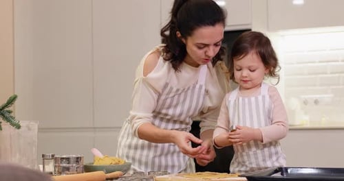 Mother and Little Child Daughter Cutting Cookies of Raw Gingerbread Dough