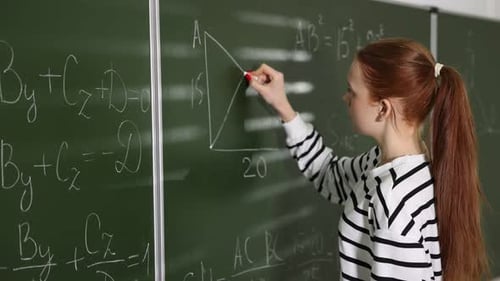 Woman Solving Math Equation on Chalkboard in Classroom