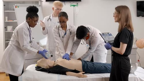 Medical students training cpr and first aid on a dummy with a teacher