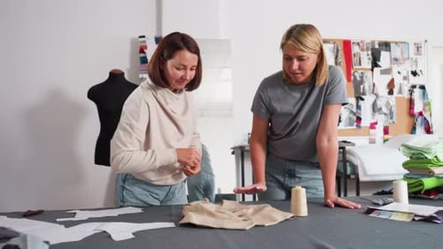 Garment Designers Discuss Button Placement On Jacket In Fashion Studio
