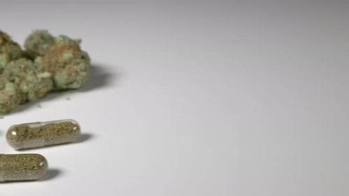 Cannabis Buds and Cannabis Pills on White Surface
