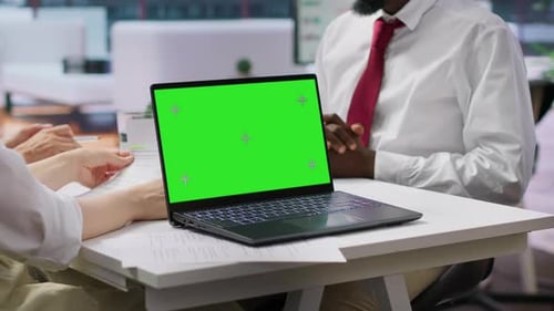 Les intervieweurs rencontrent un candidat à un poste à propos d'un poste vacant à côté d'un écran vert