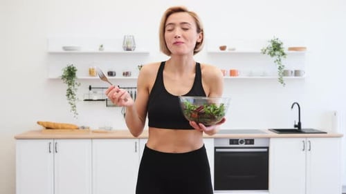 Woman Eats Healthy Salad in Modern Kitchen